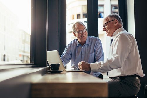 Business men working together in modern cafe