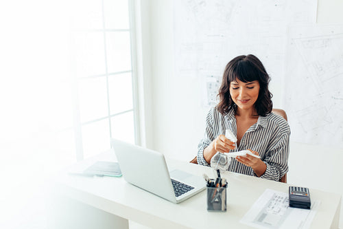 Businesswoman spraying sanitizer on cleaning tissue