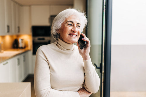 Elderly woman speaking on a phone call at home