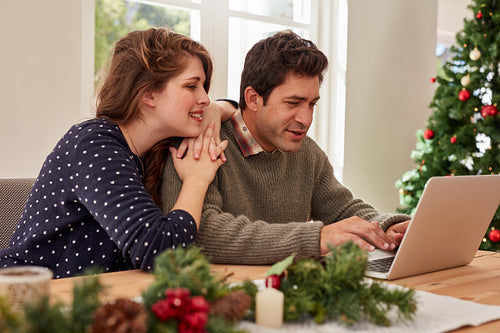 Young couple at home shopping online for christmas