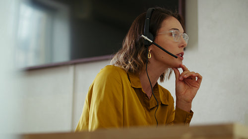 Businesswoman in headset working on computer in call center