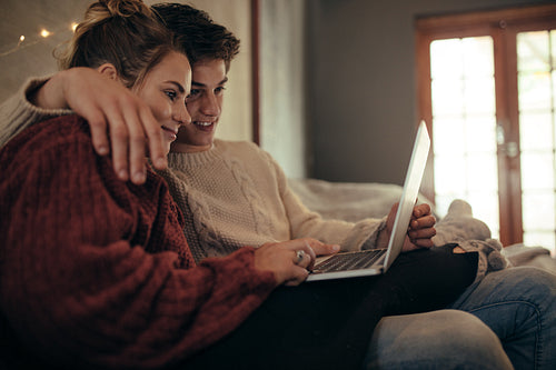 Couple using laptop in living room