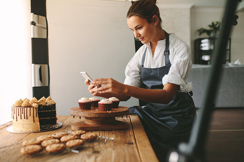 Confectioner photographing pastries