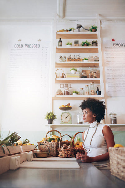 Young woman behind juice bar counter