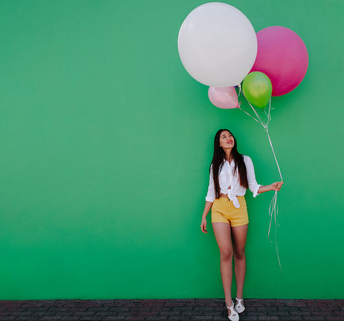 Young woman holding colorful balloons