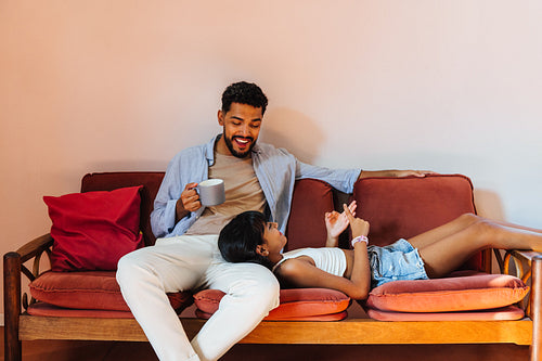 Father and daughter bonding together on a cozy couch at home