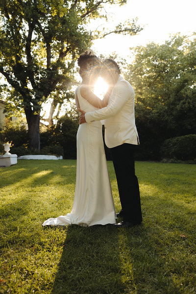 Elegant couple embracing during a sunset wedding outdoors in a garden forest setting