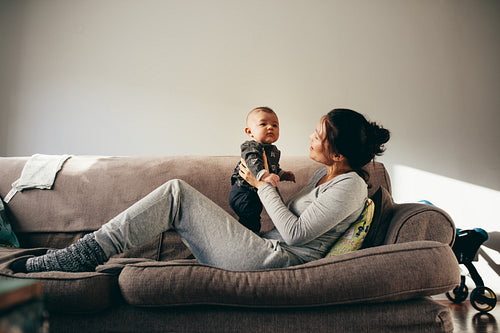 Woman sitting on couch with her baby