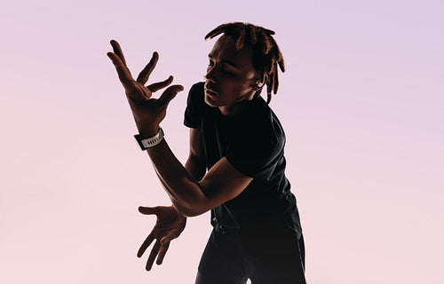 Silhouette of gen z dancer moving to wireless beats