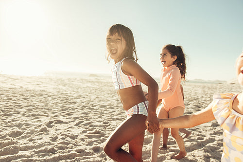 Adorable little kids running together at the beach