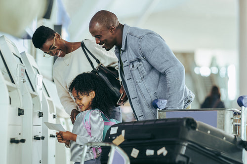 Family at airport checking boarding pass