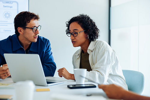 Man and woman discuss data on laptop