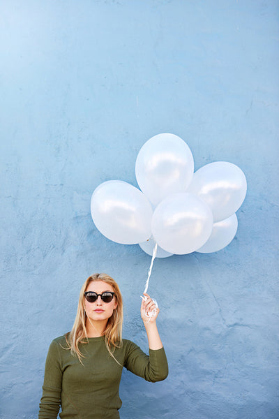 Beautiful young woman with bunch of balloons