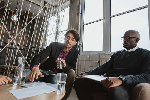 Young man discussing business strategy with colleagues