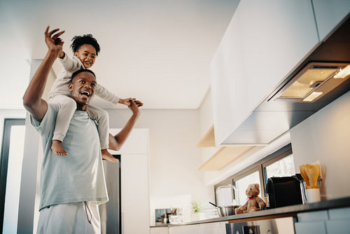 Dad dances with his daughter sitting on his shoulders