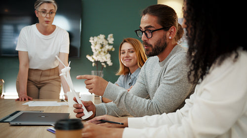 Discussions for a windmill project: Creative business people brainstorming wind energy ideas using a 3D model