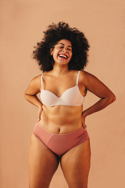 Body positive woman laughing happily in underwear