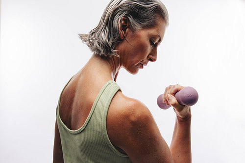 Woman lifting dumbbell in studio