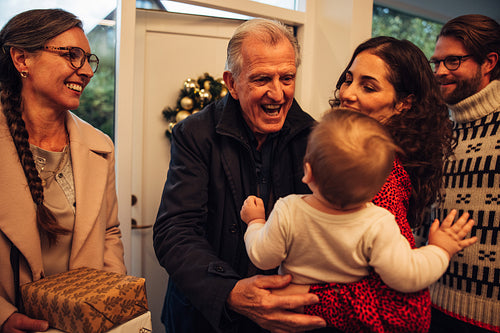 Family welcoming grandparents for christmas eve celebrations