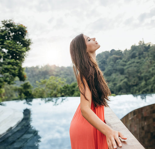 Attractive woman standing by a railing near swimming pool