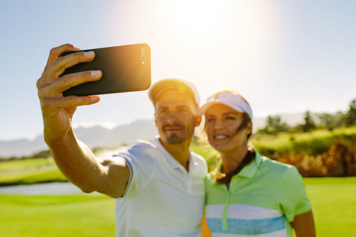 Young couple taking self portrait at golf course