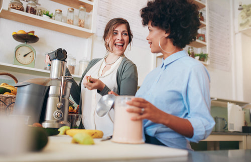 Two young women working at juice bar