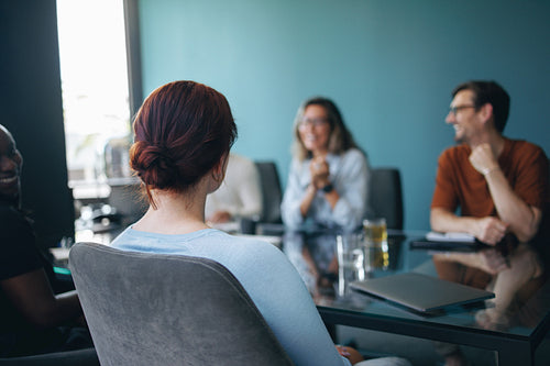 Business woman sitting in a boardroom meeting, engaging with her colleagues in a discussion