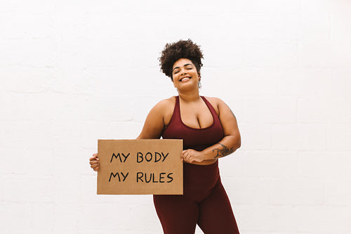 Confident woman holding "My body my rules" sign