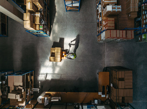 Overhead shot of a logistics worker pushing a pallet jack
