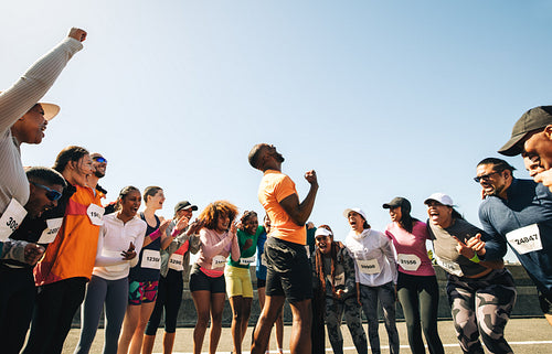 Cheerful group of runners celebrating after a successful race finish