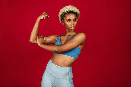 Portrait of fitness woman showing biceps