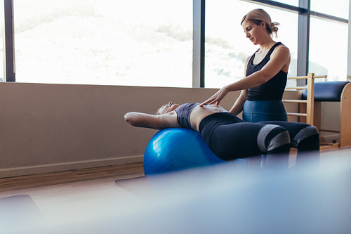 Woman training on exercise ball in a pilates training gym