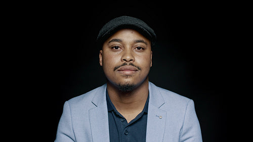 Smiling man in suit and cap