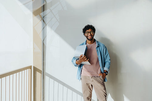 Successful young entrepreneur working in a modern office with a balcony