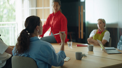 Coworkers shape business ideas as woman leads discussion in a conference room