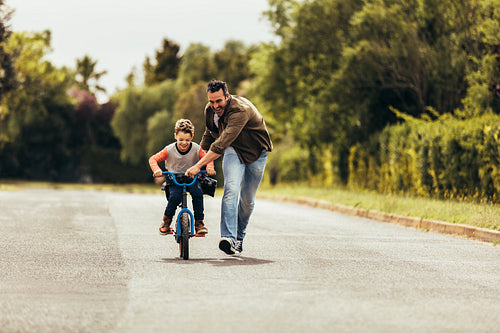 Father teaching his son to ride a bicycle