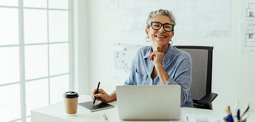 Designing with experience, senior graphic designer creates exceptional graphics at her desk