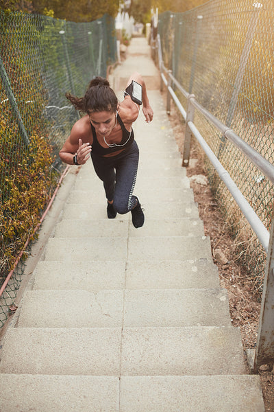Fit young woman running up stairs