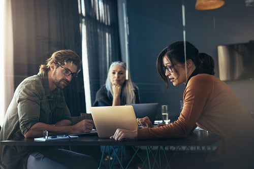 Woman sharing her ideas with laptop to colleagues