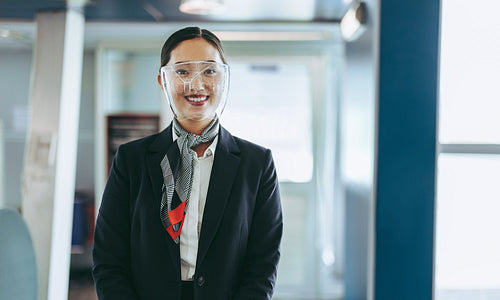 Flight attendant with face shield welcoming travelers