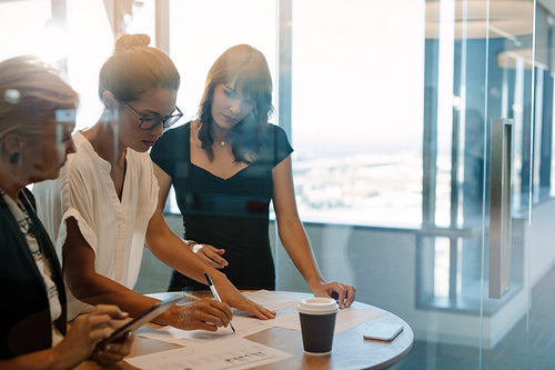 Businesswomen standing at the table and discussing new strategies