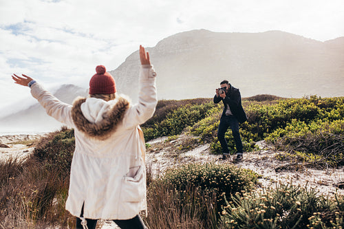 Man taking a pictures of his girlfriend on vacation
