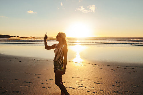 Beautiful woman taking selfie at beach