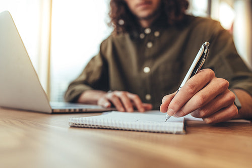 Entrepreneur making notes at his desk.