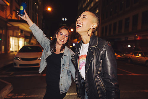 Two young city friends having fun at night