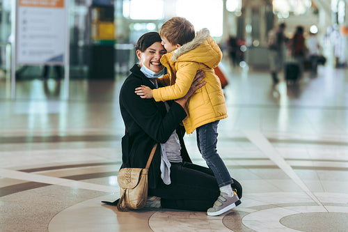 Happy woman meeting her son at airport arrivals