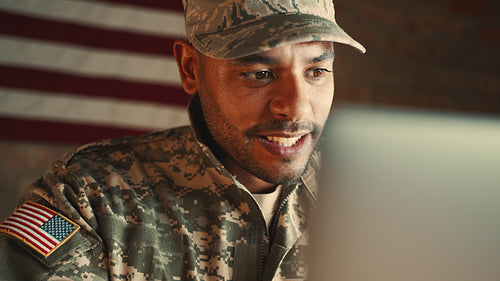 Family support during patriotic duty: Deployed military man having a video call with his loved ones on a laptop