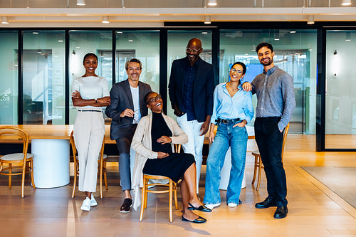 Diverse group of colleagues smiling and posing in a professional office space