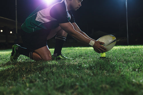 Rugby player placing the ball on tee for penalty 