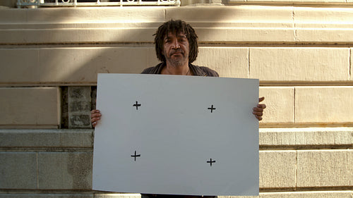 Unhappy homeless man with blank placard